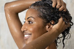 A person lathering their hair with shampoo